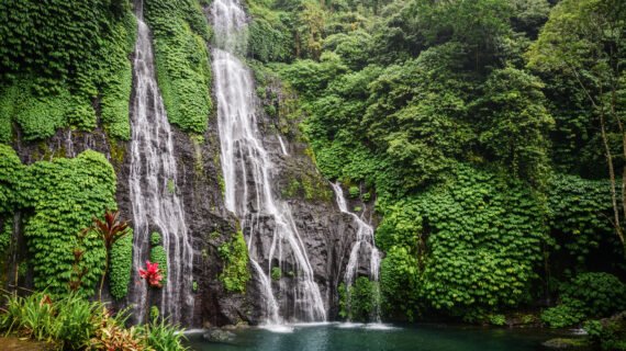 Jungle waterfall cascade in tropical rainforest with rock and turquoise blue pond. Banyumala twin waterfall in Bali, Indonesia.